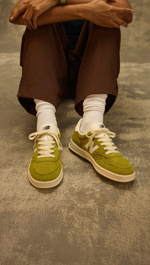 Knee down shot of a person sitting on a grungy studio backdrop 